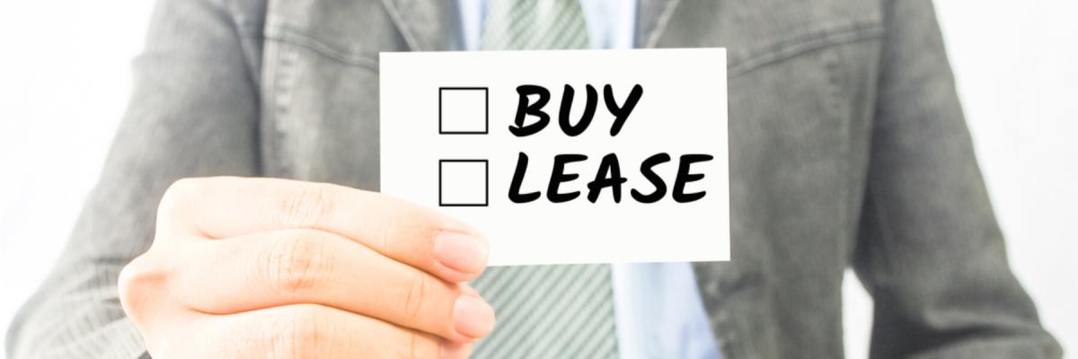 businessman holding card to check off buy or lease
