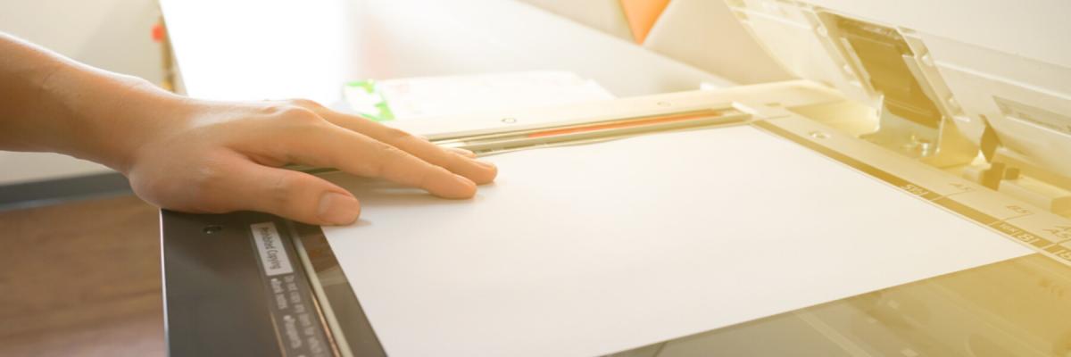 hand on paper in copier